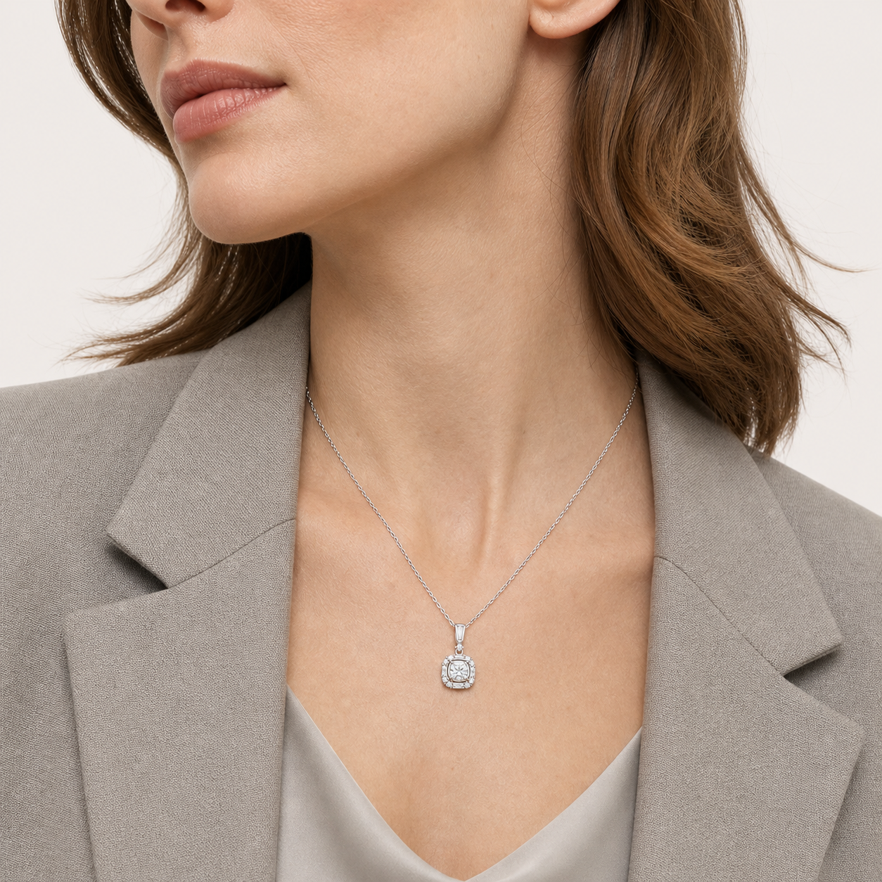 Model wearing a silver MINARIA square halo necklace with a grey blazer